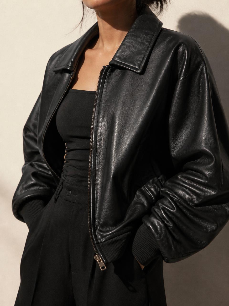 Oversized black leather jacket in soft daylight